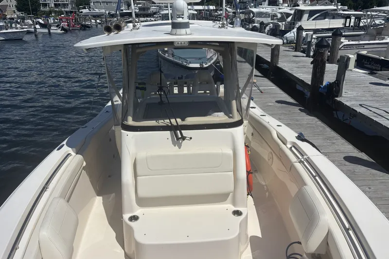 Slide: The Image of 2021 Grady-White Canyon 306 boat docked at marina, showcasing spacious deck and seating. - 10