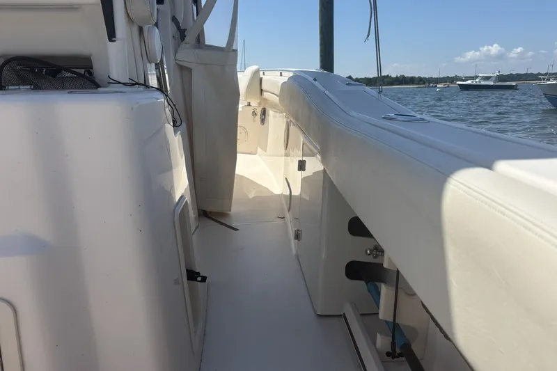 Slide: The Image of 2021 Grady-White Canyon 306 boat interior with sleek white seating and storage compartments. - 15