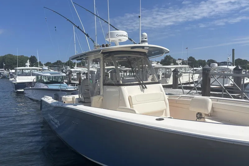 Slide: The Image of 2021 Grady-White Canyon 306 boat docked at marina under clear blue sky. - 2