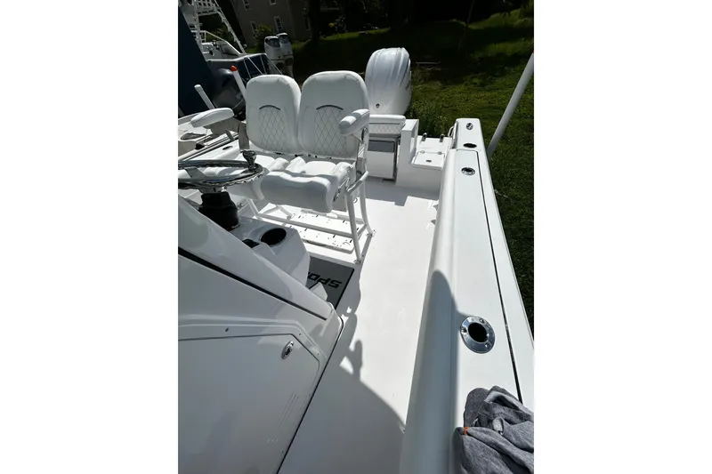 Slide: The Image of 2026 Sportsman Open 232 Center Console boat interior with white seating and steering wheel. - 5