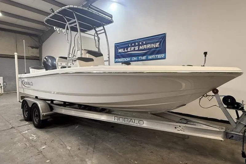 Slide: The Image of 2020 Robalo 206 Cayman boat on trailer in showroom, Miller's Marine banner visible. - 1
