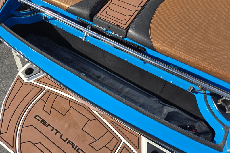 Slide: The Image of 2021 Centurion Ri257 boat interior with blue accents and brown seating. - 20