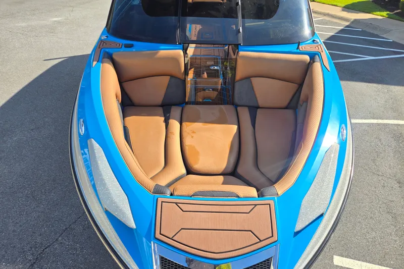Slide: The Image of 2021 Centurion Ri257 boat with tan seating and blue exterior, parked on pavement. - 25