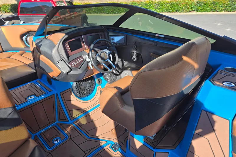 Slide: The Image of 2021 Centurion Ri257 boat interior with modern dashboard and brown seating. - 15