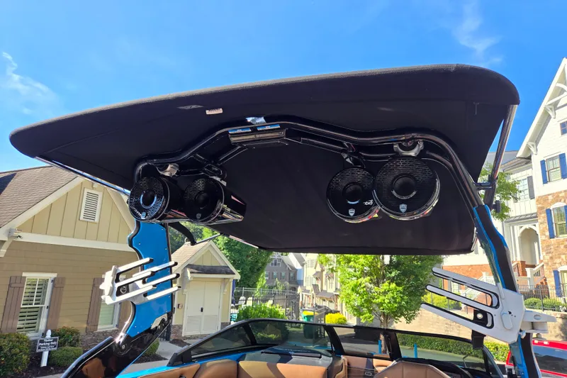 Slide: The Image of 2021 Centurion Ri257 boat with speakers and wakeboard racks under a canopy. - 32