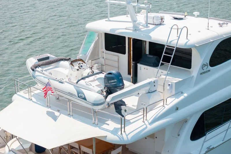 Slide: The Image of 2019 Horizon PC65 yacht with a small boat on deck, American flag displayed. - 6