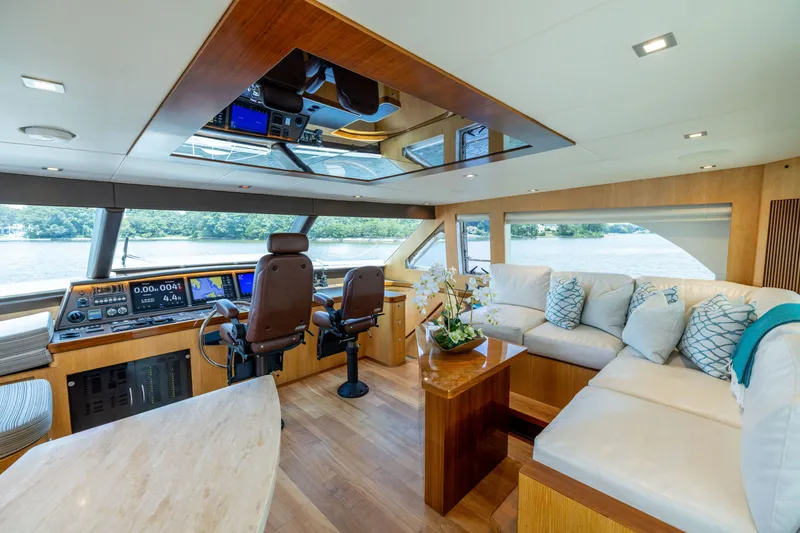 Slide: The Image of Luxurious 2019 Horizon PC65 yacht interior with plush seating, modern helm, and scenic water views. - 13