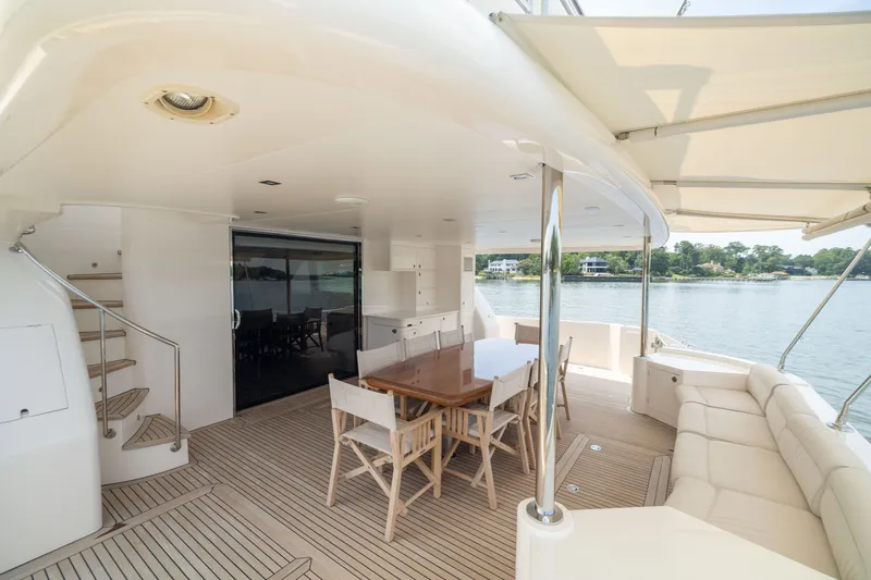 Slide: The Image of Luxurious 2019 Horizon PC65 yacht deck with dining area and scenic waterfront view. - 7