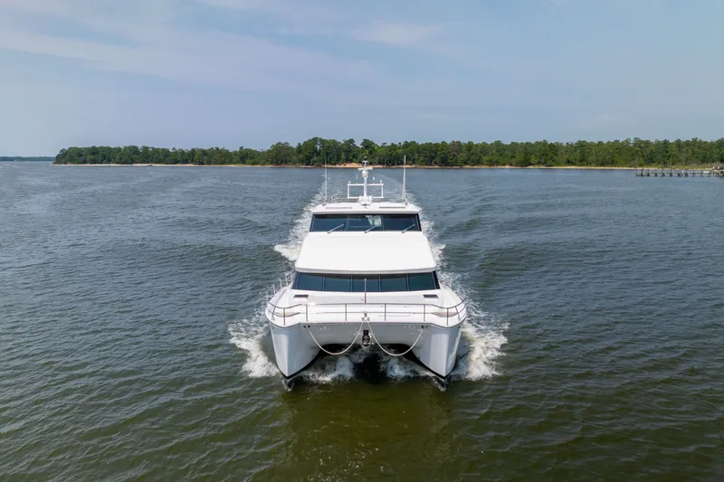 Slide: The Image of 2019 Horizon PC65 yacht cruising on open water, with lush shoreline in the background. - 3