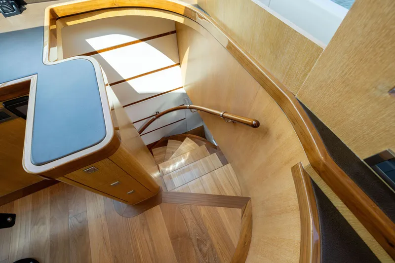 Slide: The Image of Wooden staircase with curved railing inside a 2019 Horizon PC65 yacht. - 22
