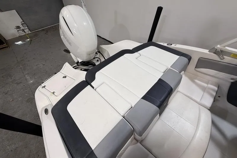 Slide: The Image of 2019 Chaparral 23 H2O Sport boat with cushioned seating and outboard motor. - 6