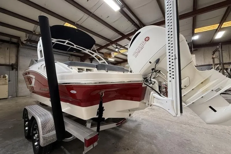 Slide: The Image of 2019 Chaparral 23 H2O Sport boat with Yamaha engine in a warehouse setting. - 4