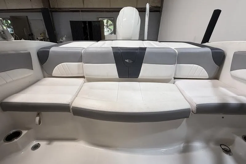 Slide: The Image of 2019 Chaparral 23 H2O Sport boat interior seating, featuring gray and white upholstery. - 8