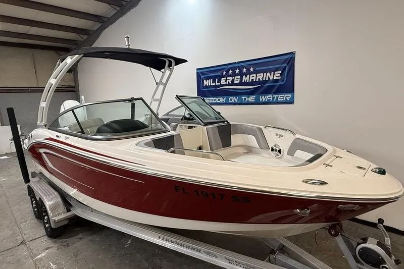 Slide: The Image of 2019 Chaparral 23 H2O Sport boat in showroom, red and white design. - 2