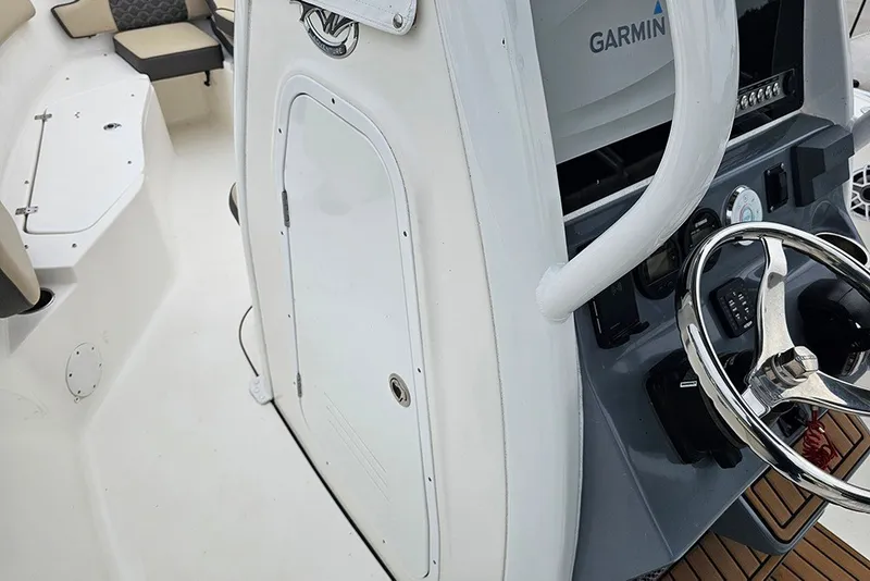 Slide: The Image of 2021 Tidewater 232 CC Adventure boat interior with steering wheel and Garmin equipment. - 19