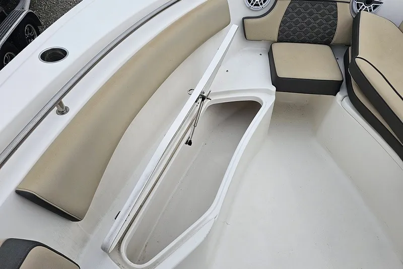 Slide: The Image of 2021 Tidewater 232 CC Adventure boat interior with open storage compartment and cushioned seating. - 22