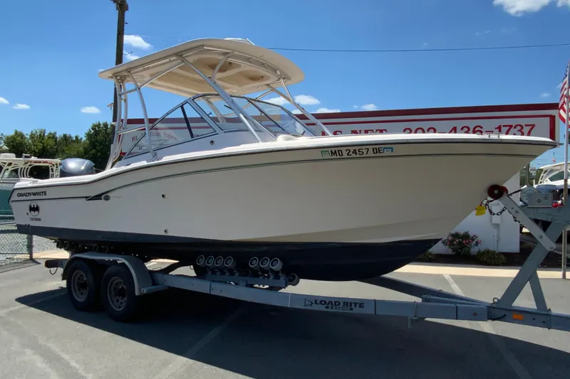 Slide: The Image of 2011 Grady-White Freedom 255 boat on trailer at dealership, sunny day. - 2