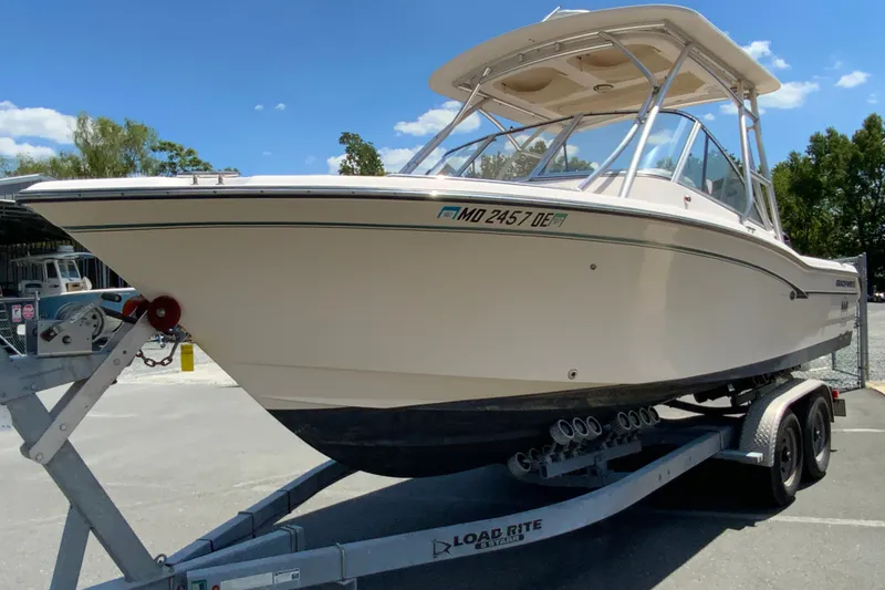 Slide: The Image of 2011 Grady-White Freedom 255 boat on trailer under clear blue sky. - 5