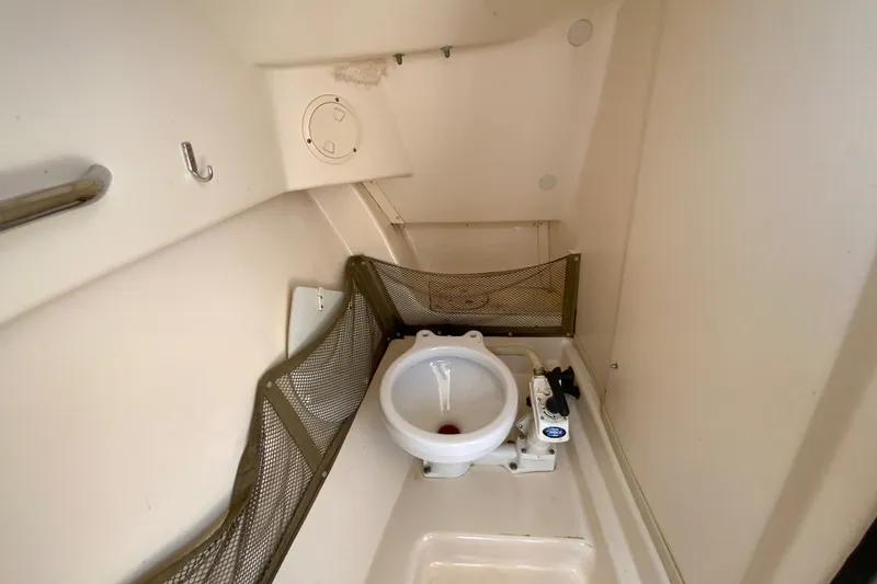 Slide: The Image of Interior of 2011 Grady-White Freedom 255 boat, featuring a compact marine toilet. - 23