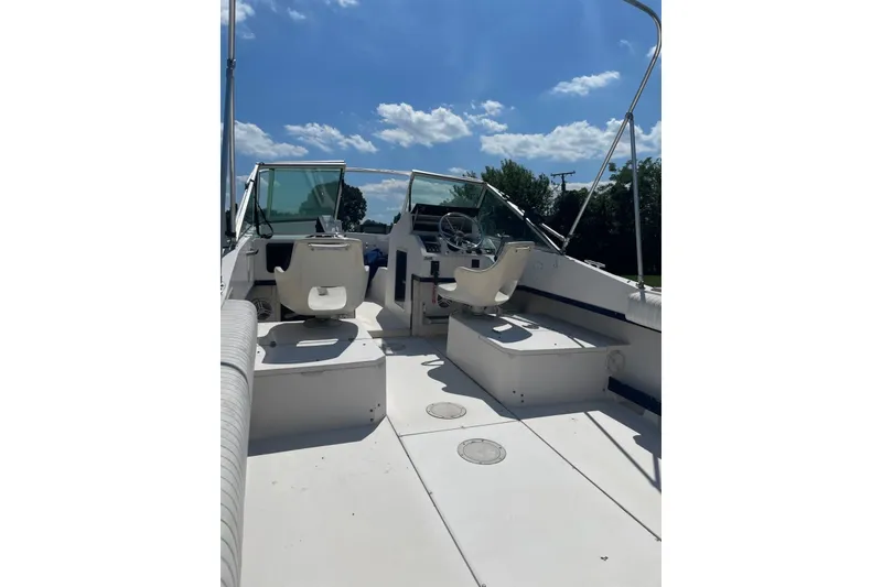 Slide: The Image of 1990 Grady-White Tournament 192 boat interior with dual seats and steering wheel under blue sky. - 11