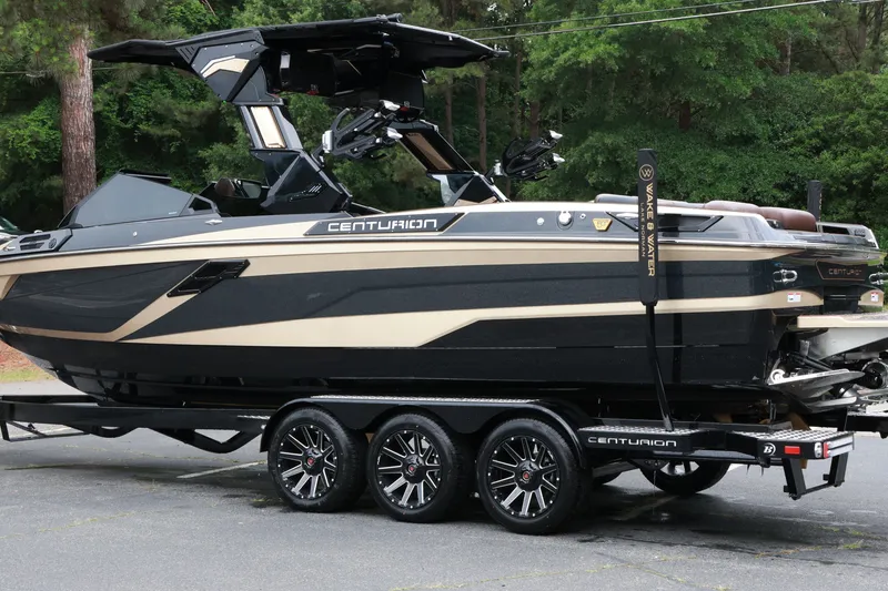 Slide: The Image of 2026 Centurion Ri265 boat on trailer, sleek design, black and beige color scheme. - 5