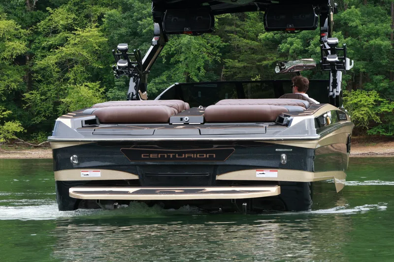 Slide: The Image of 2026 Centurion Ri265 boat cruising on a lake with lush green forest backdrop. - 3