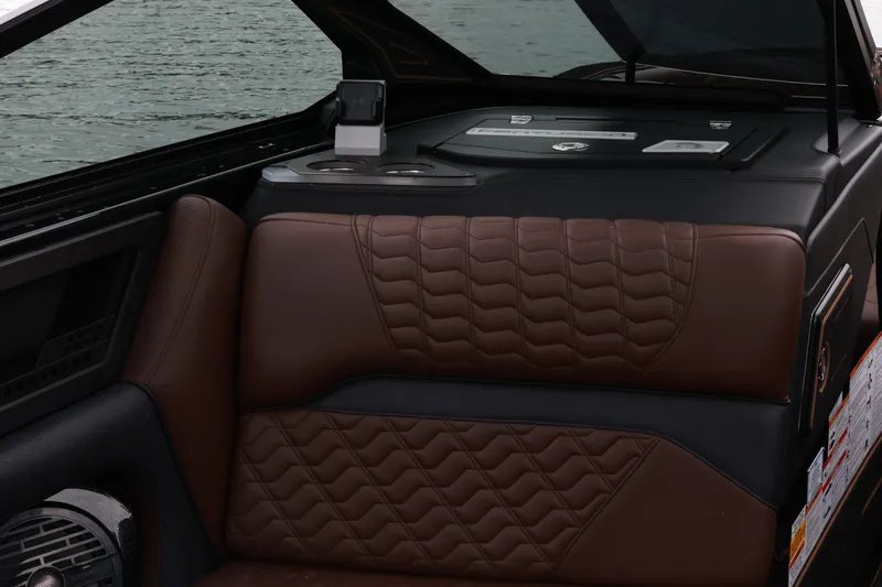 Slide: The Image of 2026 Centurion Ri265 interior with brown quilted seating and cup holders by the water. - 11