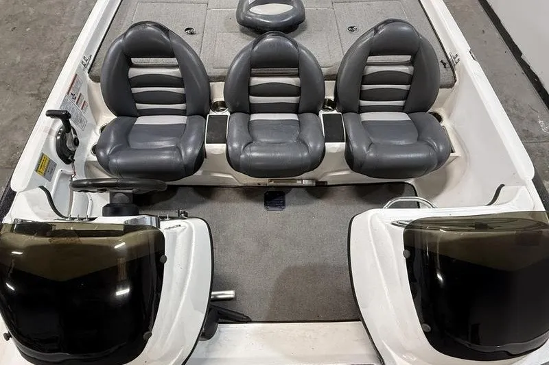 Slide: The Image of 2009 Nitro Z-7 boat interior with three gray seats and dual consoles. - 6