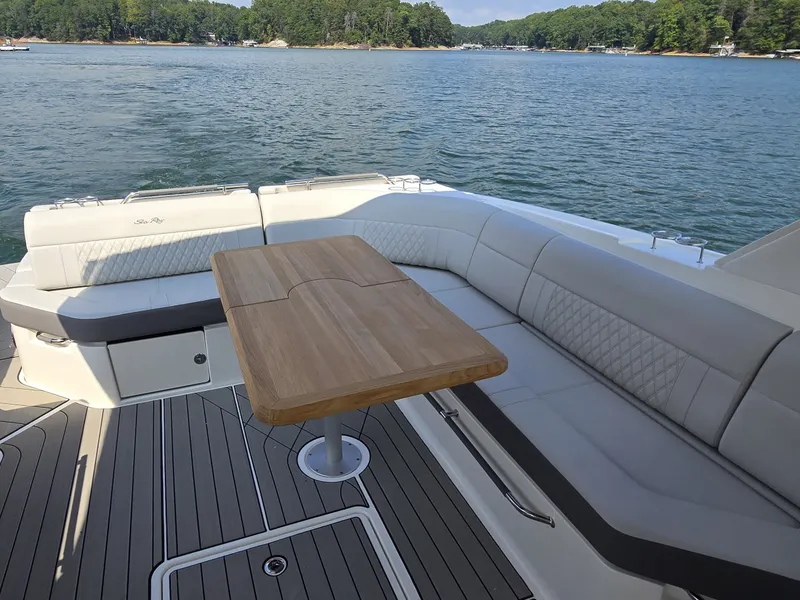 Slide: The Image of The 2027 Sea Ray SLX 400 features an elegant seating area with a wooden table overlooking the water. - 14