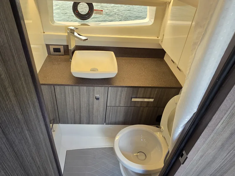 Slide: The Image of The image shows a modern boat bathroom with a sink, toilet, and window. - 37