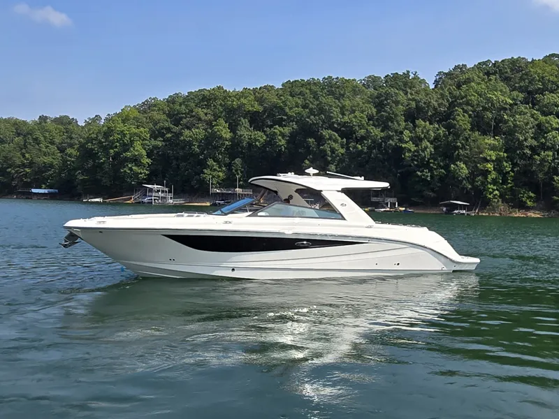 Slide: The Image of A sleek, white 2027 Sea Ray SLX 400 boat on a calm lake. - 46