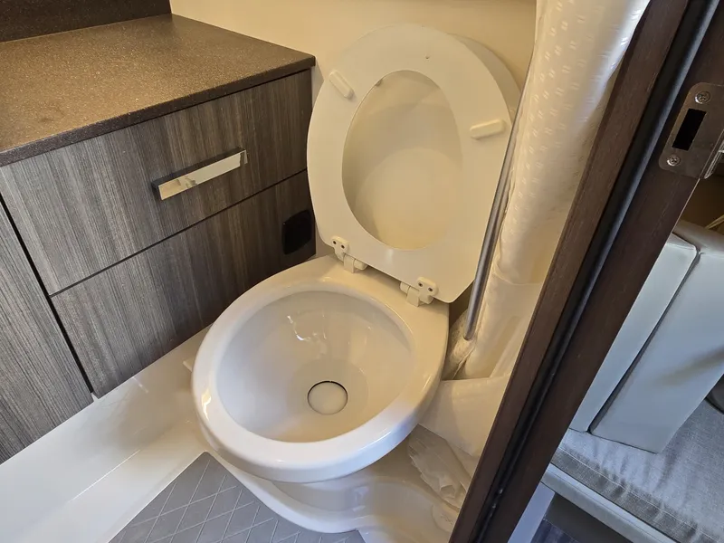 Slide: The Image of Interior of the Sea Ray SLX 400 featuring a toilet and cabinet. - 38