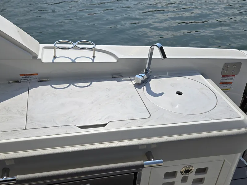 Slide: The Image of The 2027 Sea Ray SLX 400 features a sleek outdoor kitchen with a sink and storage. - 16