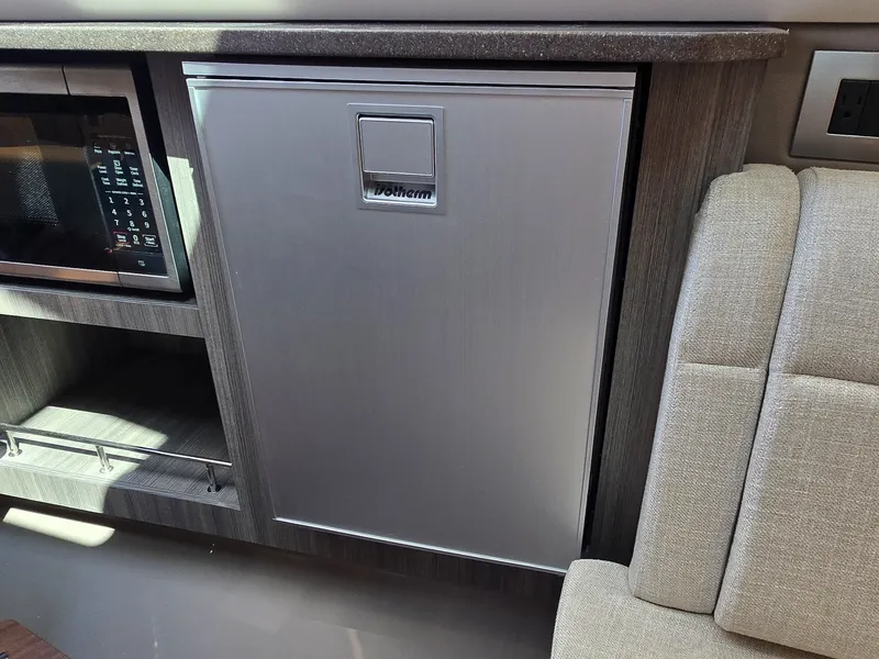 Slide: The Image of Galley area with microwave and fridge in a 2027 Sea Ray SLX 400. - 35