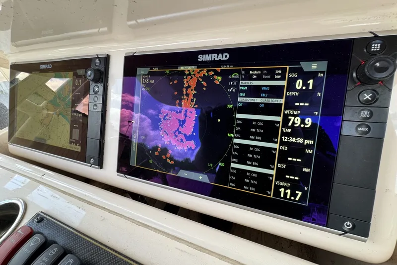 Slide: The Image of Simrad navigation displays on a 2014 Grady-White Canyon 283 boat dashboard. - 14