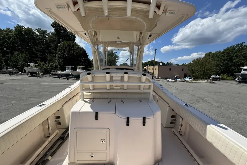 Slide: The Image of 2014 Grady-White Canyon 283 boat interior with rod holders and storage, parked outdoors. - 23
