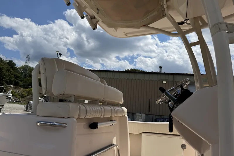 Slide: The Image of 2014 Grady-White Canyon 283 boat interior with helm and seating under a cloudy sky. - 33