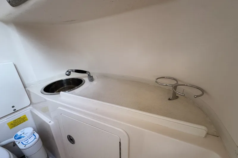 Slide: The Image of Interior of 2014 Grady-White Canyon 283 boat featuring a compact sink and cup holders. - 21