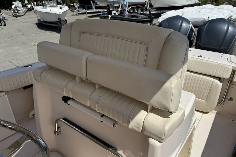 Slide: The Image of 2014 Grady-White Canyon 283 boat interior with cushioned seating and steering wheel. - 27