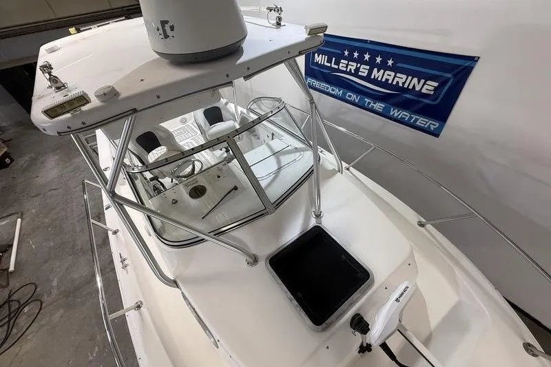 Slide: The Image of 2002 Sea Pro 235 Walk Around boat in showroom, featuring sleek design and spacious cockpit. - 22