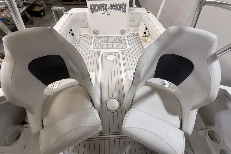 Slide: The Image of 2002 Sea Pro 235 Walk Around boat interior with two white seats and deck view. - 14
