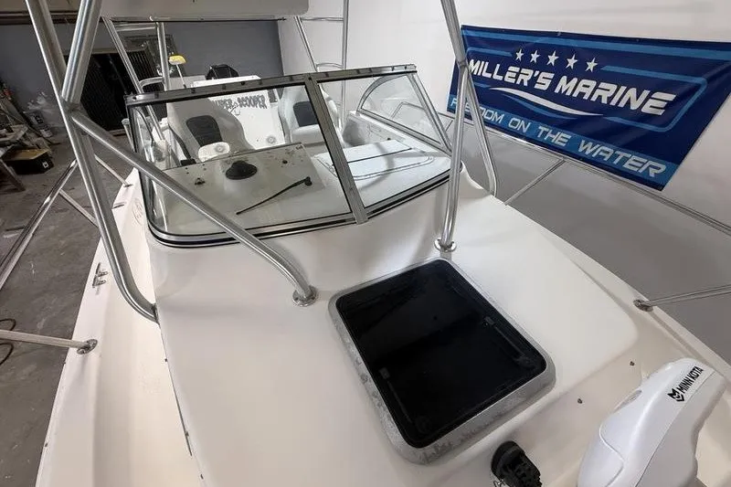 Slide: The Image of 2002 Sea Pro 235 Walk Around boat with windshield and open hatch, displayed indoors. - 19
