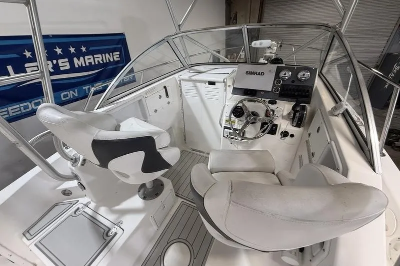 Slide: The Image of 2002 Sea Pro 235 Walk Around boat cockpit with steering wheel and seating. - 18