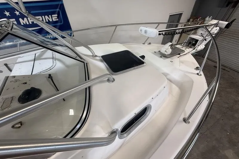 Slide: The Image of 2002 Sea Pro 235 Walk Around boat deck with railing and hatch in a showroom. - 21