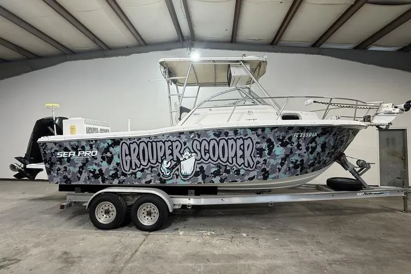 The Image of 2002 Sea Pro 235 Walk Around boat with "Grouper Scooper" graphics on trailer. - 0