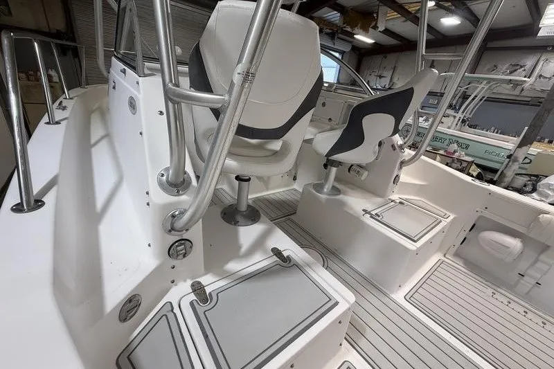 Slide: The Image of 2002 Sea Pro 235 Walk Around boat interior with seating and storage compartments. - 7