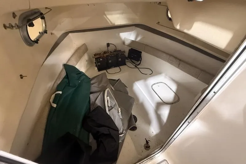 Slide: The Image of 2002 Sea Pro 235 Walk Around cabin interior with storage bags and equipment. - 15