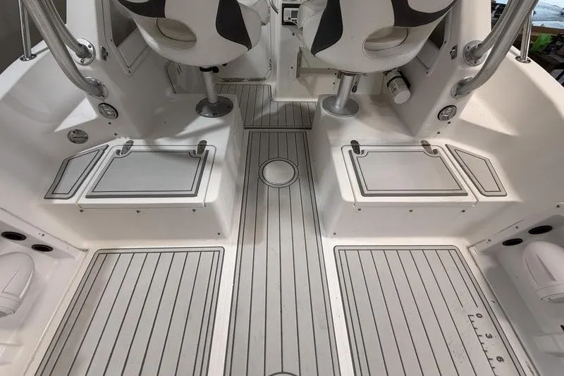 Slide: The Image of Interior view of a 2002 Sea Pro 235 Walk Around boat, featuring seating and storage compartments. - 8