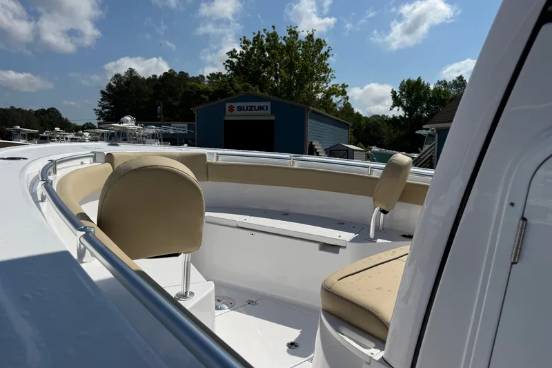 Slide: The Image of 2026 Sportsman Open 212 Center Console boat with beige seating, under a clear blue sky. - 2