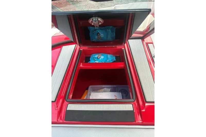 Slide: The Image of Red 2021 Moomba Kaiyen boat storage compartment with snacks and supplies. - 18